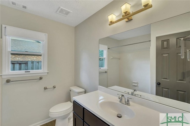 bathroom with vanity, a textured ceiling, and toilet