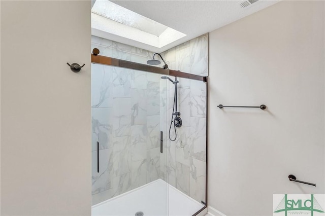 bathroom featuring a skylight and a shower with door