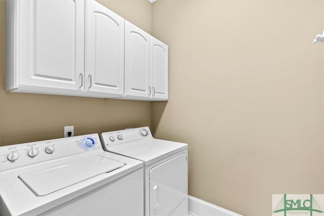 laundry area featuring washing machine and dryer and cabinets