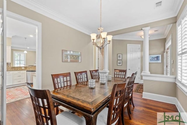 dining room with crown molding, dark hardwood / wood-style floors, and decorative columns