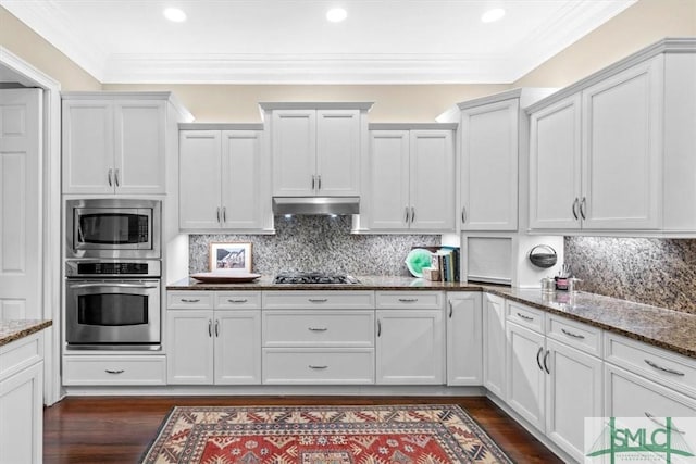 kitchen featuring stone counters, appliances with stainless steel finishes, dark hardwood / wood-style flooring, and white cabinets