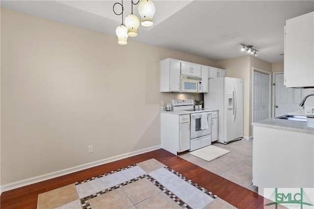 kitchen with white cabinetry, sink, light wood-type flooring, hanging light fixtures, and white appliances