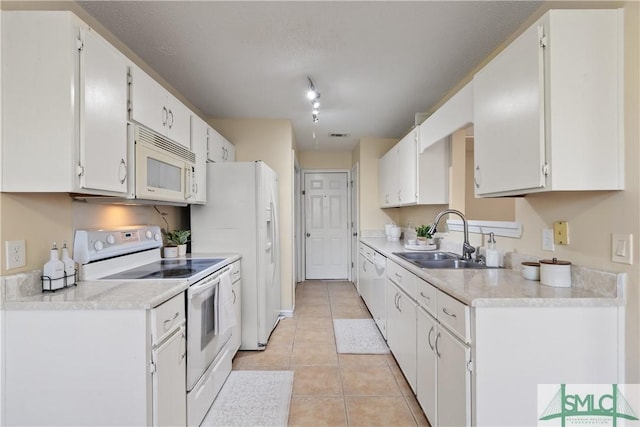 kitchen with white cabinetry, sink, light tile patterned floors, and white appliances