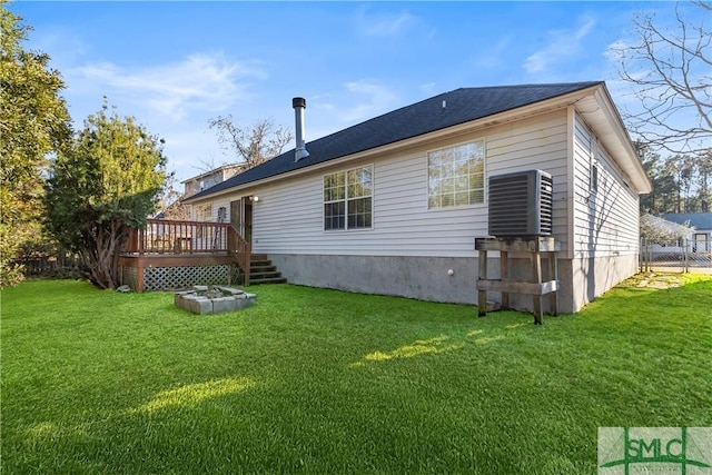 back of house with a wooden deck, central AC, and a lawn