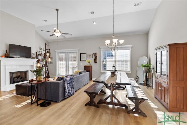 living area featuring light wood-style floors, visible vents, and a fireplace