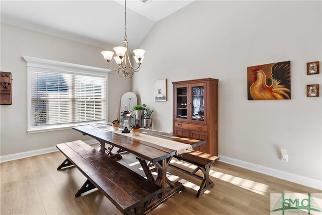 dining space with light wood-style floors, baseboards, vaulted ceiling, and an inviting chandelier