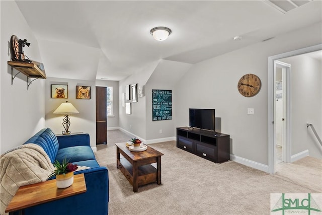 carpeted living room featuring lofted ceiling and baseboards