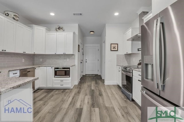 kitchen featuring white cabinetry, appliances with stainless steel finishes, light stone countertops, and light hardwood / wood-style floors