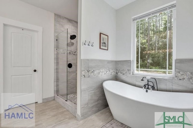 bathroom featuring separate shower and tub and tile walls