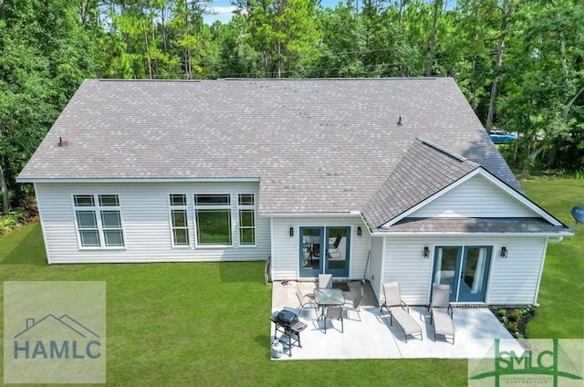 rear view of property with a lawn and a patio area