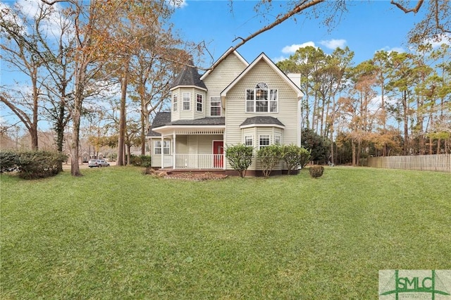 rear view of house featuring a yard and a porch