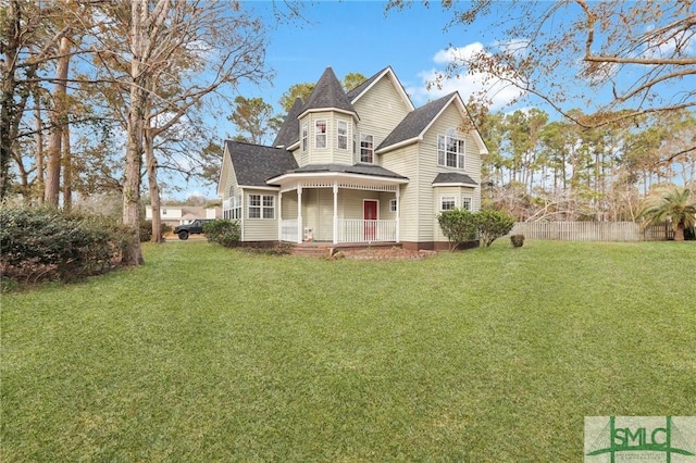 victorian-style house featuring a front yard and covered porch