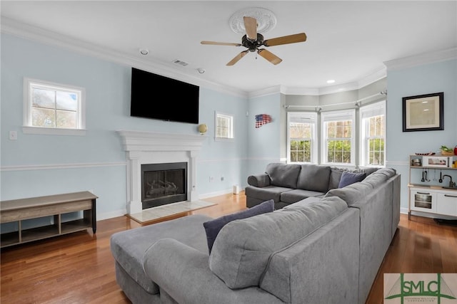 living room with crown molding, hardwood / wood-style floors, and ceiling fan