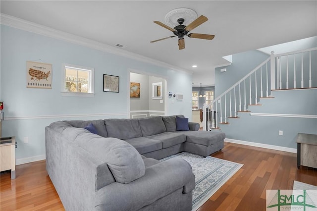 living room with hardwood / wood-style flooring, crown molding, and ceiling fan