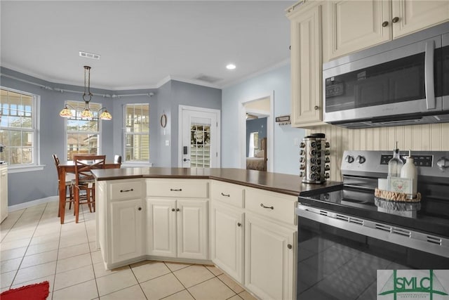 kitchen featuring hanging light fixtures, crown molding, light tile patterned flooring, and appliances with stainless steel finishes