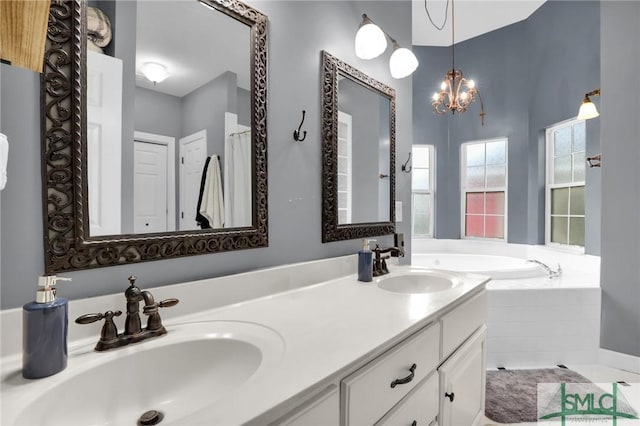 bathroom with a relaxing tiled tub, vanity, and an inviting chandelier