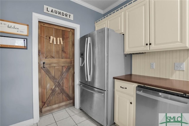 kitchen featuring ornamental molding, appliances with stainless steel finishes, cream cabinets, and light tile patterned floors