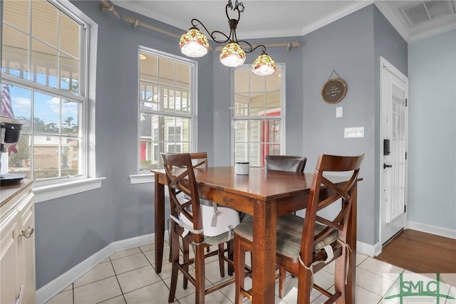 dining space featuring ornamental molding and light tile patterned floors