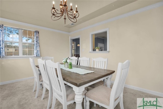 carpeted dining space featuring ornamental molding, a raised ceiling, and a notable chandelier