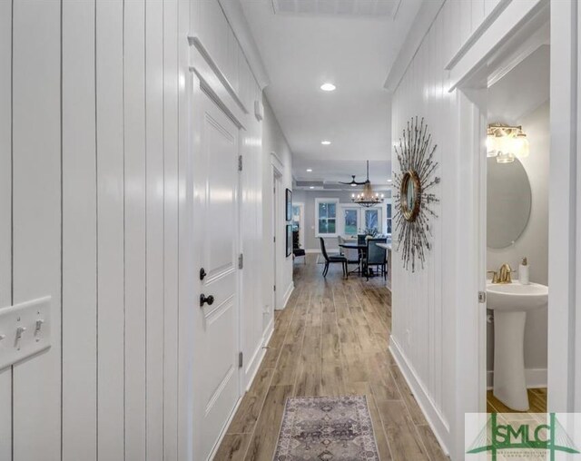 corridor with sink and light wood-type flooring