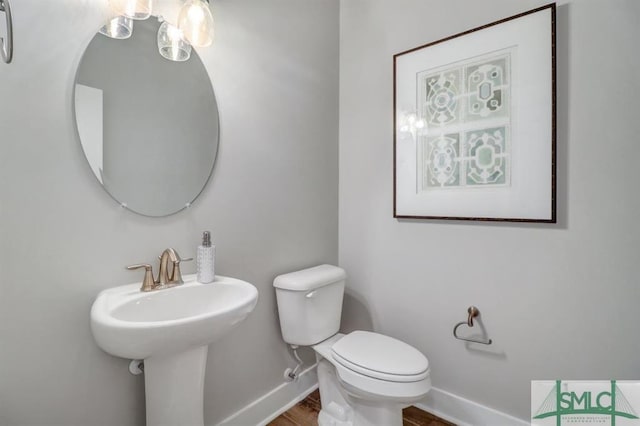 bathroom featuring hardwood / wood-style flooring and toilet