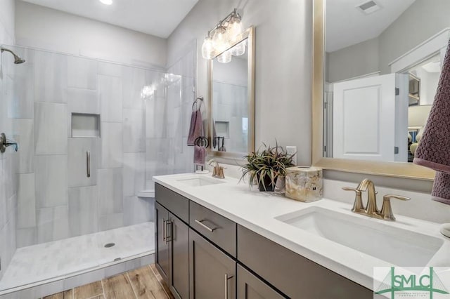 bathroom with vanity, hardwood / wood-style flooring, and a shower with shower door