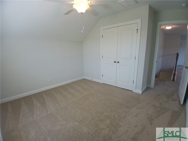 unfurnished bedroom with vaulted ceiling, carpet flooring, ceiling fan, and a closet