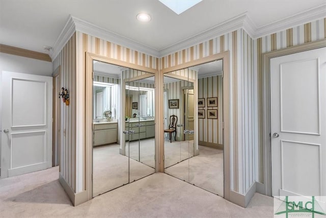 interior space featuring crown molding, a skylight, and light colored carpet