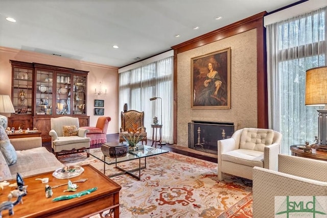 living room with crown molding and a large fireplace