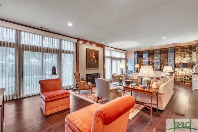 living room with ornamental molding, a fireplace, and dark hardwood / wood-style flooring