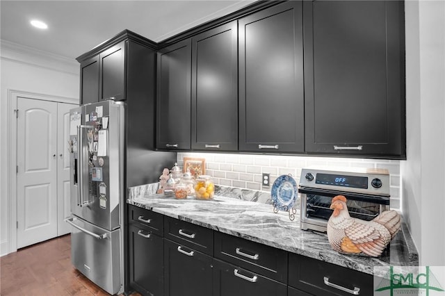 kitchen featuring light stone counters, ornamental molding, high end refrigerator, and backsplash