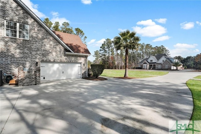 view of side of home with a garage and a lawn