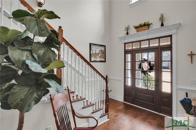 foyer entrance featuring dark hardwood / wood-style flooring and a towering ceiling