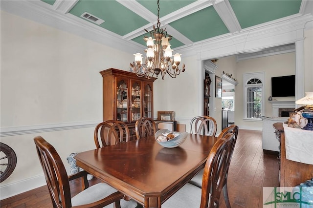 dining room with dark hardwood / wood-style floors, ornamental molding, coffered ceiling, and a notable chandelier