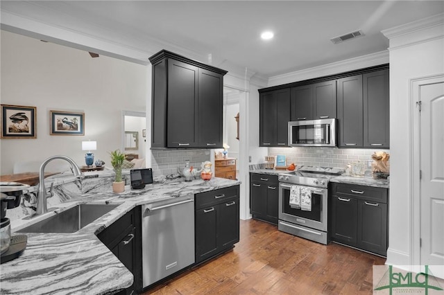 kitchen featuring sink, ornamental molding, stainless steel appliances, and light stone countertops