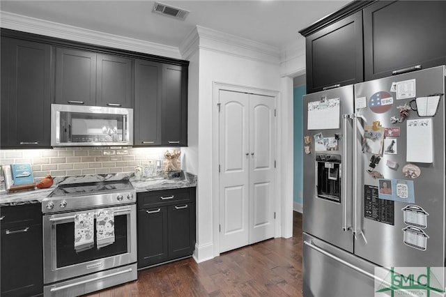 kitchen with dark wood-type flooring, crown molding, tasteful backsplash, stainless steel appliances, and light stone countertops