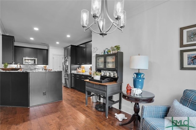 kitchen featuring tasteful backsplash, ornamental molding, dark wood-type flooring, and light stone counters