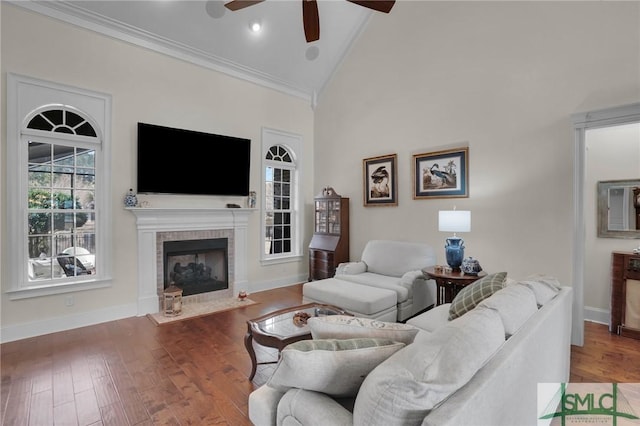 living room with crown molding, high vaulted ceiling, a brick fireplace, ceiling fan, and hardwood / wood-style floors