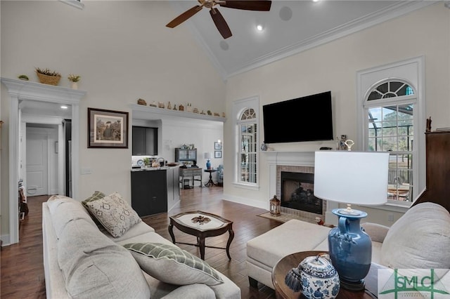 living room with crown molding, ceiling fan, high vaulted ceiling, dark hardwood / wood-style floors, and a fireplace