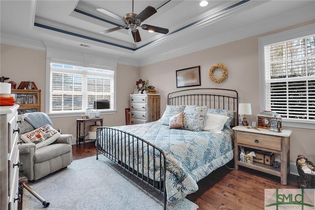 bedroom with a raised ceiling, crown molding, hardwood / wood-style flooring, and ceiling fan