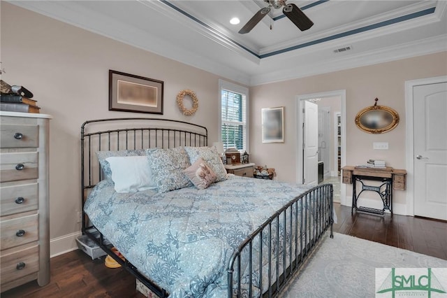 bedroom featuring ceiling fan, ornamental molding, dark hardwood / wood-style flooring, and a tray ceiling