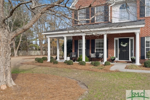 exterior space featuring covered porch and a front lawn