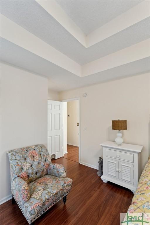 sitting room with dark hardwood / wood-style flooring and a tray ceiling