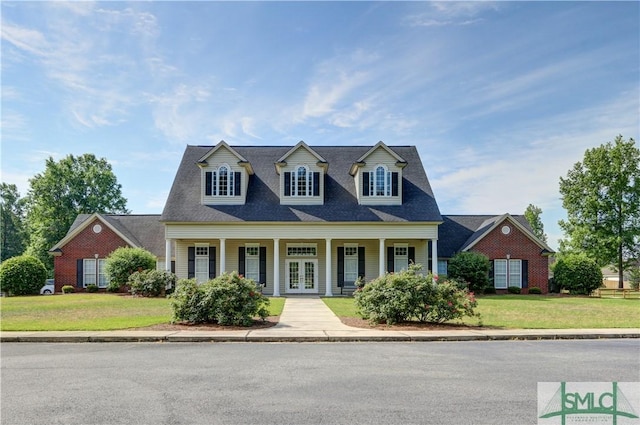 new england style home featuring french doors and a front yard