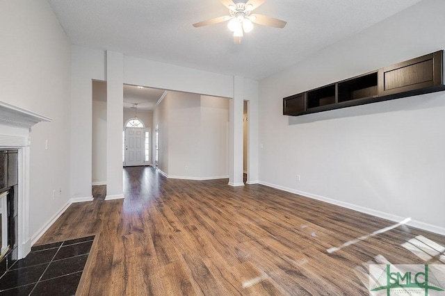 unfurnished living room featuring dark hardwood / wood-style floors and ceiling fan