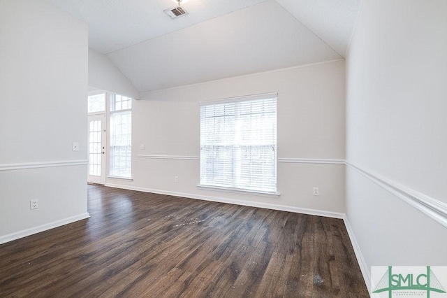 empty room with lofted ceiling, dark wood-type flooring, and plenty of natural light