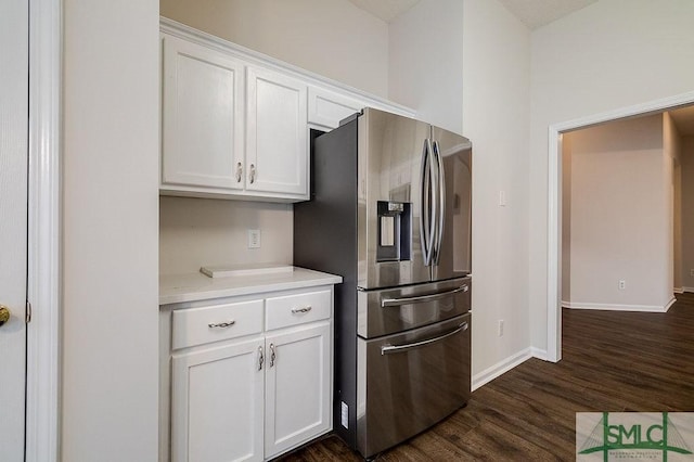 kitchen with white cabinetry, dark hardwood / wood-style floors, and stainless steel fridge