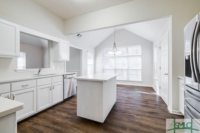 kitchen with dark wood-type flooring, sink, hanging light fixtures, appliances with stainless steel finishes, and white cabinets