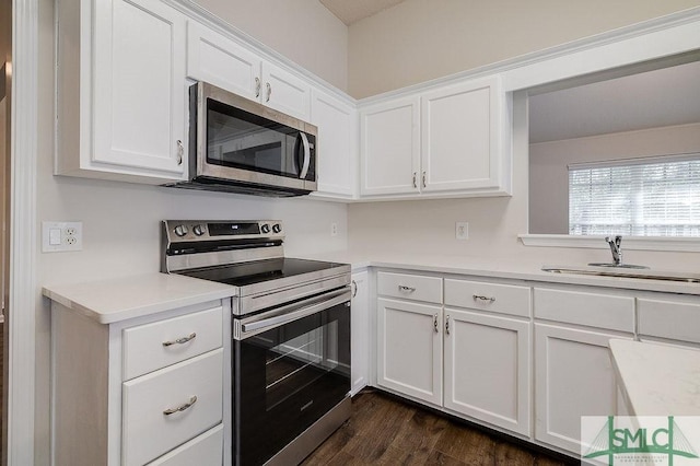 kitchen with stainless steel appliances, white cabinetry, sink, and dark wood-type flooring