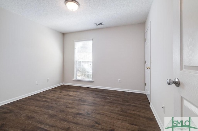 unfurnished room featuring dark hardwood / wood-style flooring and a textured ceiling